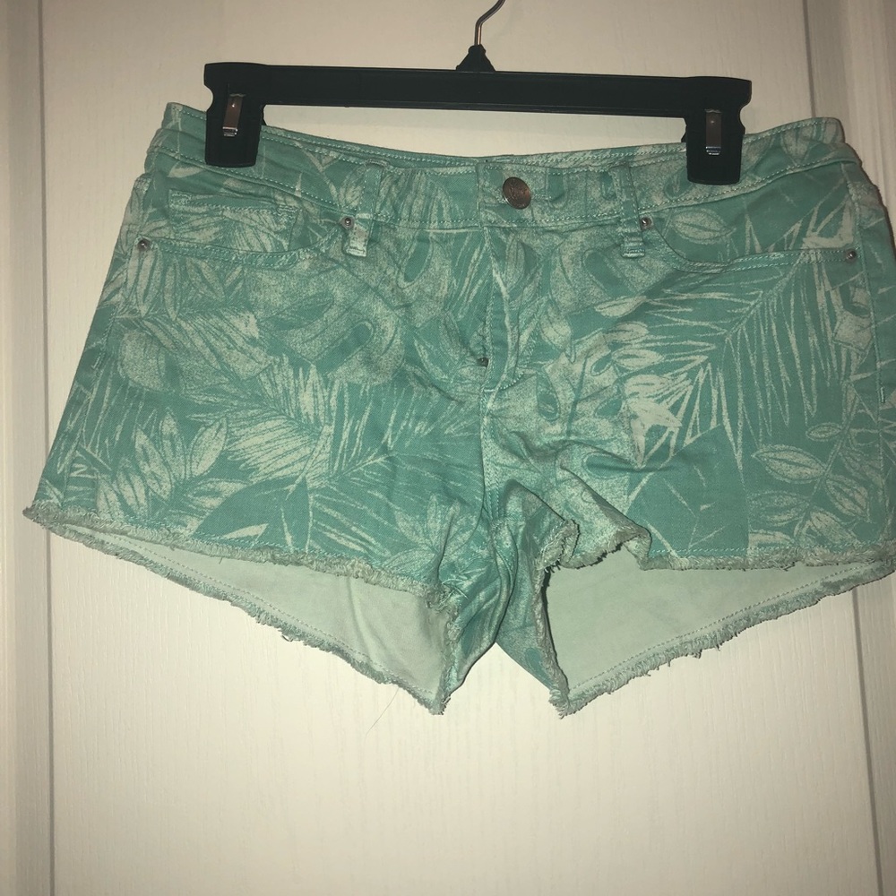 Teal shorts with leaves on them